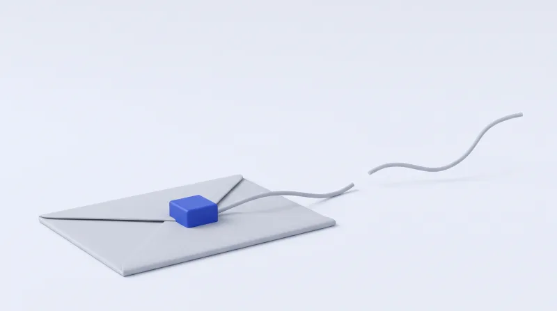 A small blue cube resting on a grey envelope, with the cord leading away from it cut and curling loose in mid-air